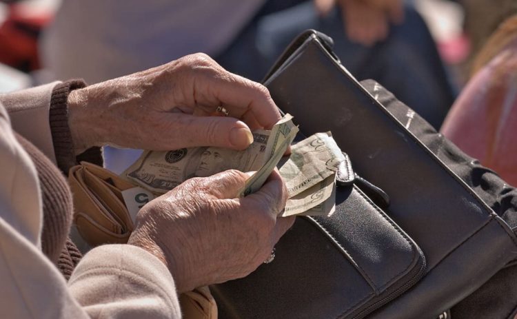 Senior citizen with money in hand from Social Security - Canva