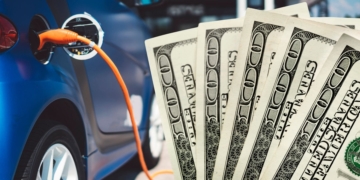 One electric Car is charging and there are some dollars next to it