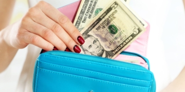 A woman is putting her Social Security money in her purse