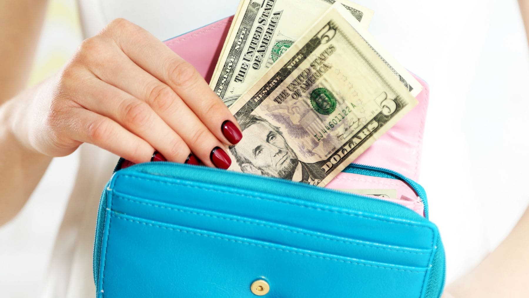 A woman is putting her Social Security money in her purse