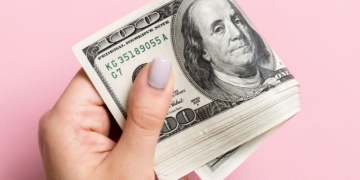 A man holding money from the Supplemental Security Income with a pink bottom