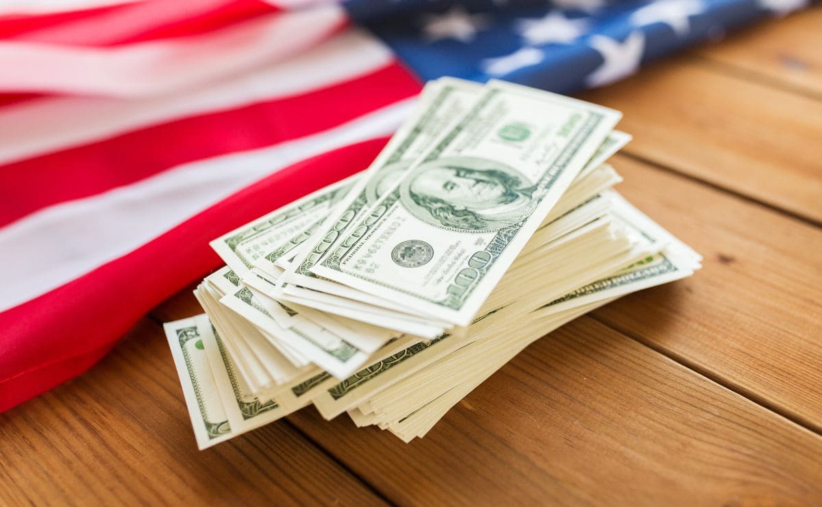 Stimulus check money in cash with an American Flag