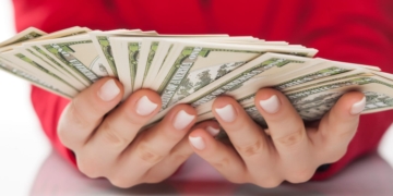 Hands holding dollars from the Social Security payment