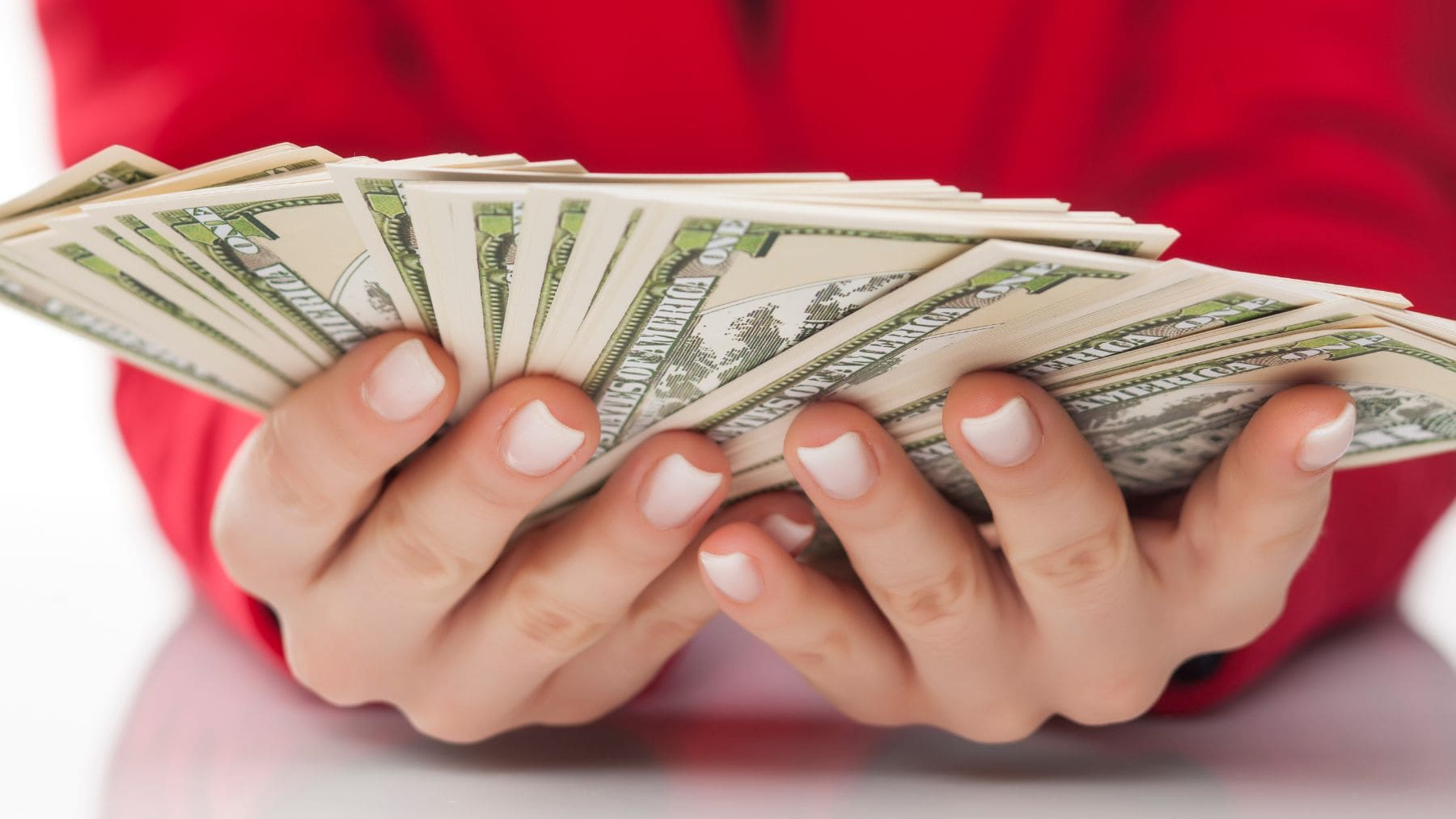 Hands holding dollars from the Social Security payment