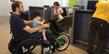 Pasajero en silla de ruedas en facturación aeropuerto