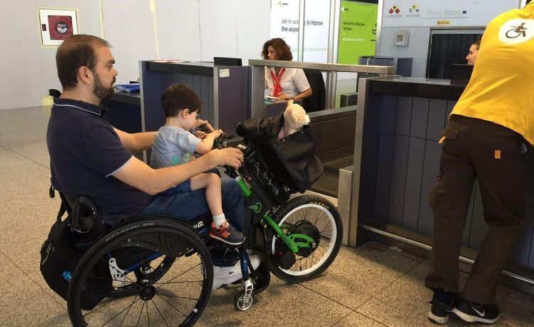 Pasajero en silla de ruedas en facturación aeropuerto