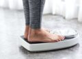 Una persona pesándose para comprobar si logra bajar de peso