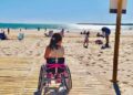 Niña de 7 años en su silla de ruedas en la pasarela playa