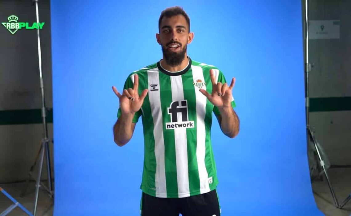 Borja Iglesias, delantero del Real Betis, hace el gesto de "Te quiero" en lengua de signos