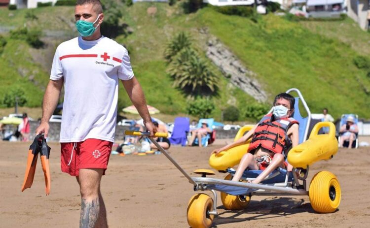 Cruz Roja ayuda al baño playa personas con discapacidad Fundacion AXA