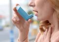 Mujer con asma usando un inhalador