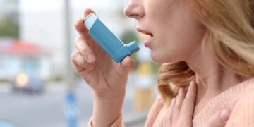 Mujer con asma usando un inhalador