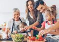 Three-generation family with two small children preparing food.