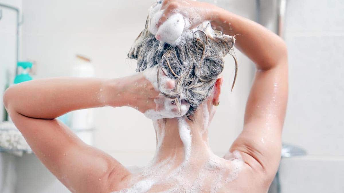 Una mujer lavándose el pelo con el nuevo champú de Mercadona