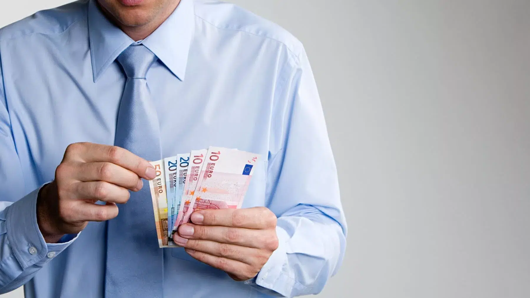 Hombre con corbata contando billetes de euros