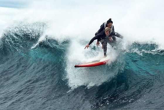 Mujer con paraplejia encima de surfero