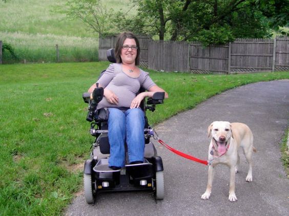 Niña en silla junto a su perro asistente