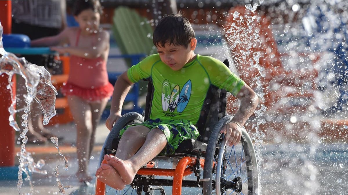 Niño en silla de ruedas en el parque acuático