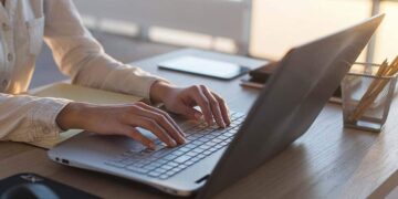 Una mujer completando su Currículum Vitae por ordenador para encontrar empleo