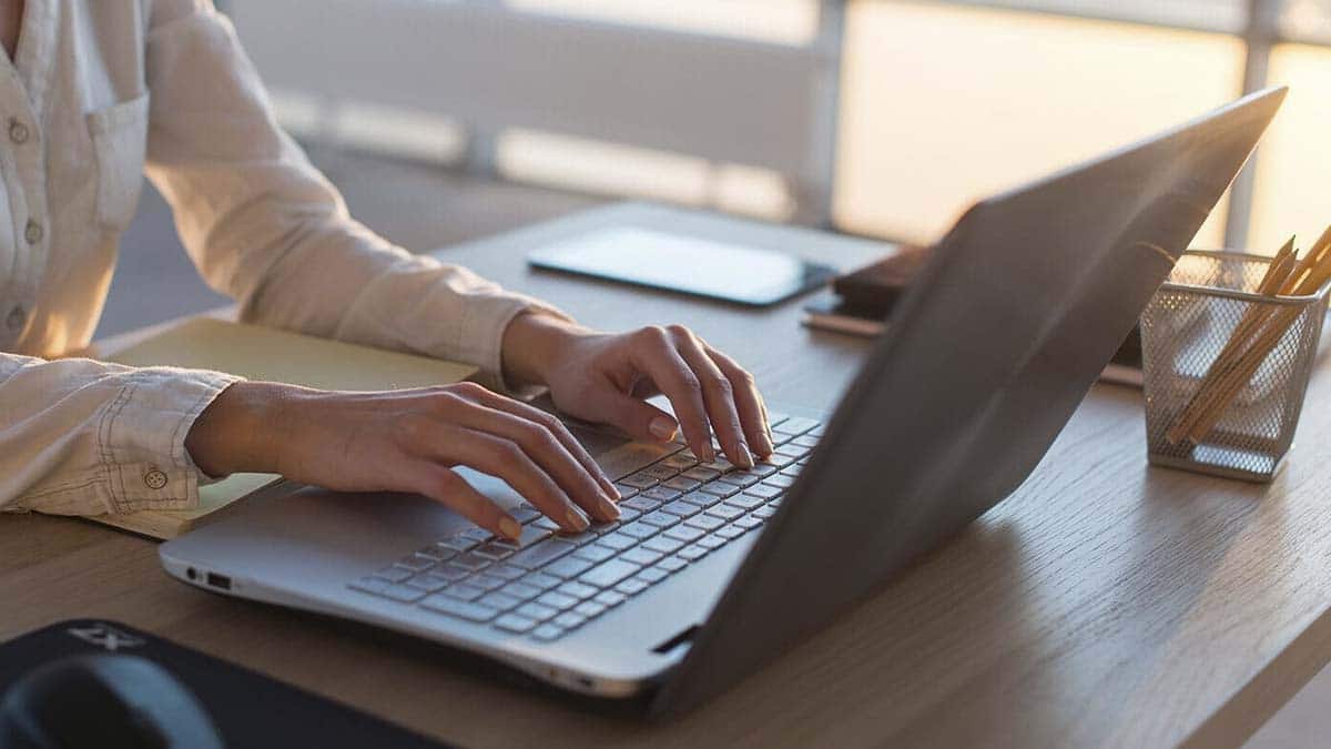 Una mujer completando su Currículum Vitae por ordenador para encontrar empleo