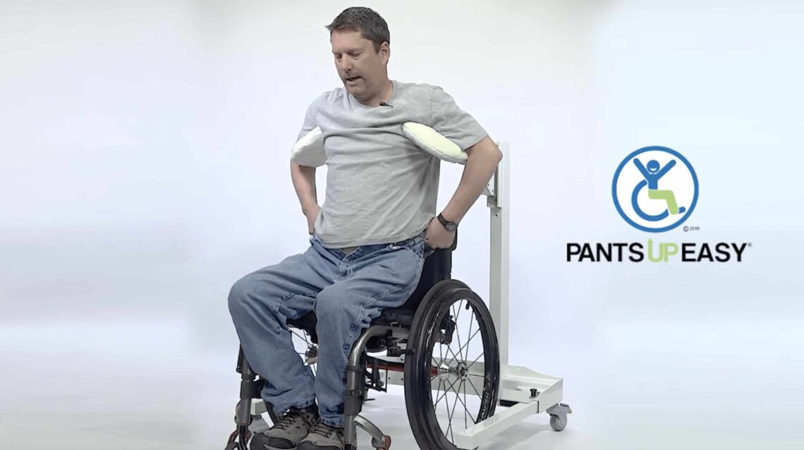 Hombre subiéndose el pantalón desde la silla de ruedas con un aparato que te sujeta las axilas para auparte