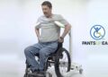 Hombre subiéndose el pantalón desde la silla de ruedas con un aparato que te sujeta las axilas para auparte