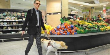 Persona ciega con perro guía en el supermercado