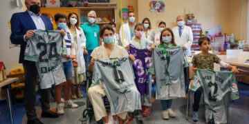 Niños en el hospital posan con las camisetas del Real Betis Balompié
