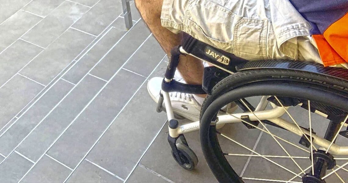 Usuario de silla de ruedas al borde de unas escaleras