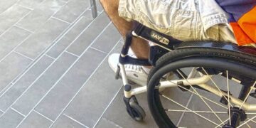 Usuario de silla de ruedas al borde de unas escaleras