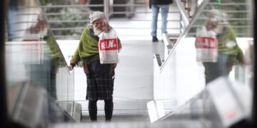 Una persona sin hogar pasea por la Estación de Atocha durante el confinamiento