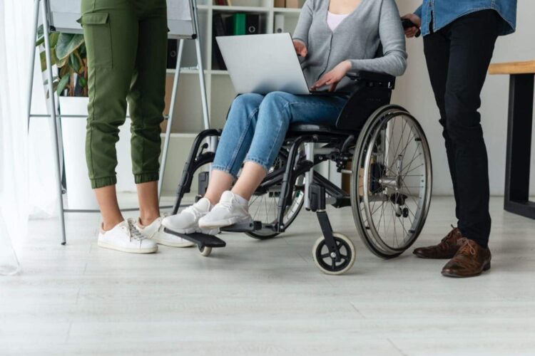 Varias personas trabajando silla de ruedas discapacidad