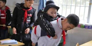 Niño que carga a otro con discapacidad