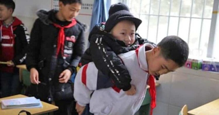 Niño que carga a otro con discapacidad