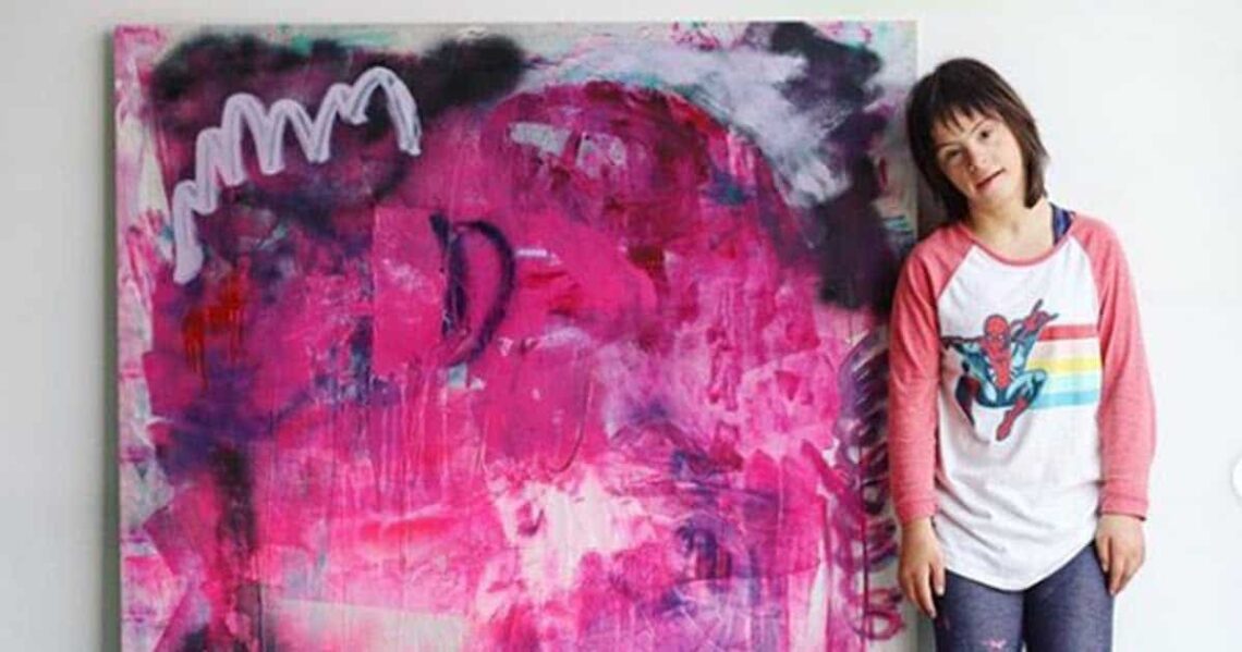 Sevy, artista con síndrome de Down, junto con una de sus pinturas