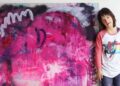 Sevy, artista con síndrome de Down, junto con una de sus pinturas