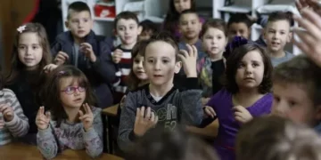 Los alumnos de una clase aprenden lengua de signos para comunicarse con un compañero sordo