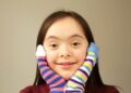 Niña con síndrome de down con calcetines dispares con motivo del Día Mundial del síndrome de Down