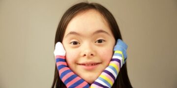 Niña con síndrome de down con calcetines dispares con motivo del Día Mundial del síndrome de Down