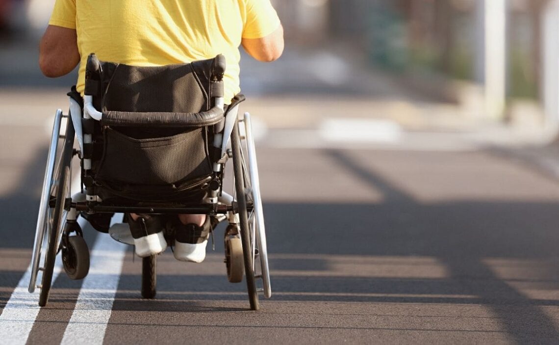 Persona en silla de ruedas pasando por el carril bici accesibilidad