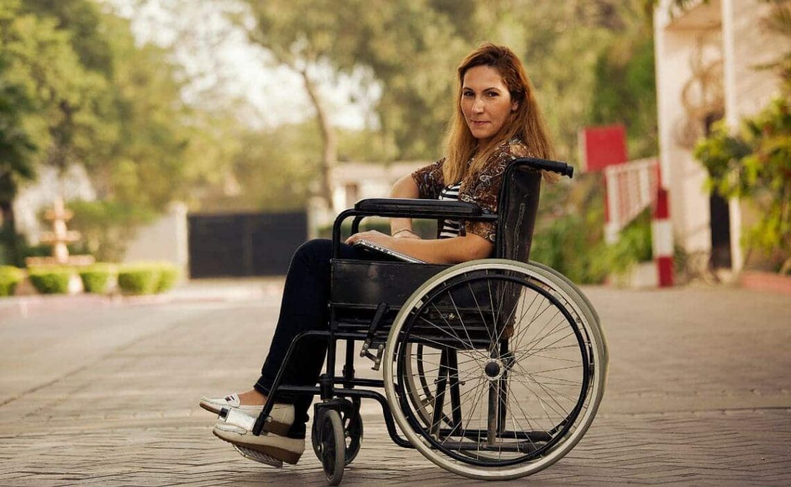 CERMI Mujer en silla de ruedas comprueba la accesibilidad de la ciudad