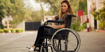 CERMI Mujer en silla de ruedas comprueba la accesibilidad de la ciudad
