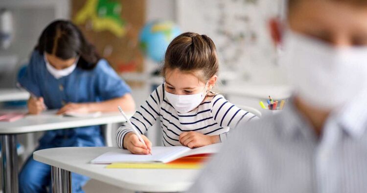 Niños con mascarilla en la vuelta al cole estudiantes