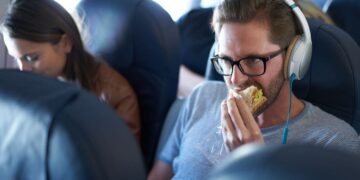 Hombre comiendo en un avión