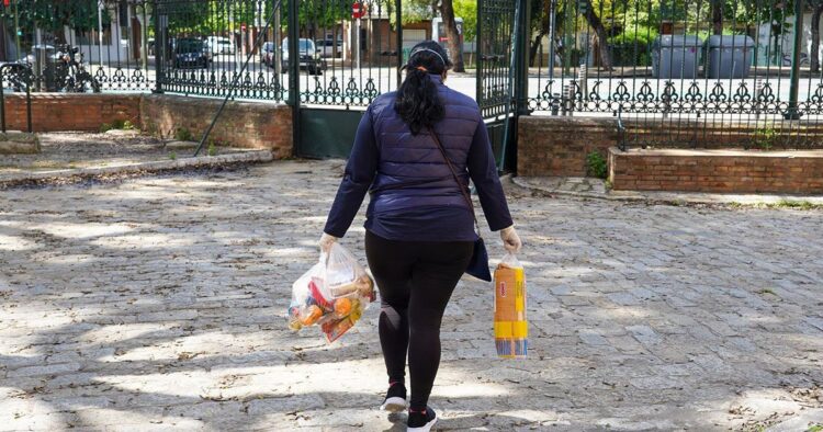 Una mujer con bolsas de la compra durante la pandemia en Sevilla