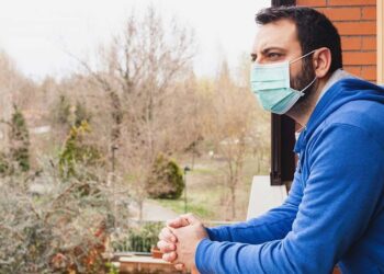 Persona con mascarilla en su casa coronavirus