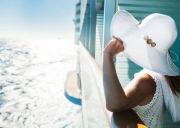 Una mujer se asoma al mar en su camarote del crucero