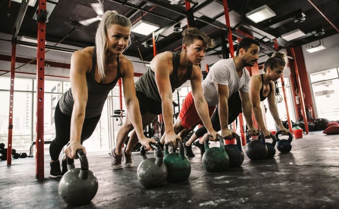 Personas realizando Crossfit, el ejercicio físico de monda en el gimnasio