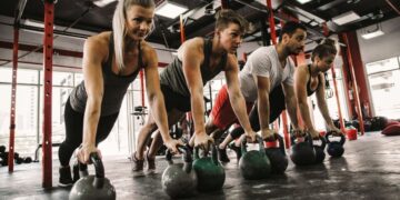 Personas realizando Crossfit, el ejercicio físico de monda en el gimnasio