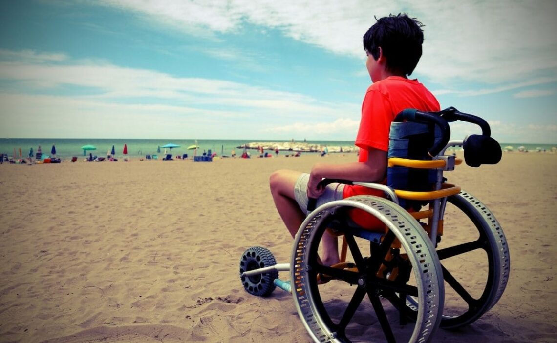 esclerosis multiple discapacidad niño silla de ruedas playa